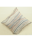 Ivory decorative cushion cover with colorful flowy line embroidery in warm tones, 18x18 inches.