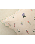 Tea Rose cushion showcasing delicate pink fabric with lavender and peach floral motifs and scalloped edges.
