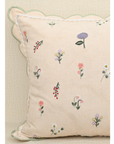Tea Rose pink cushion with floral motifs in lavender and peach, featuring scalloped edges for a touch of elegance.