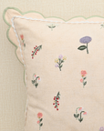 Tea Rose cushion featuring delicate floral embroidery in pink, lavender, and peach with scalloped edges.