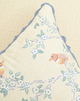 Close-up of a Hummingbirds cushion cover featuring embroidered birds and blue lace trim.