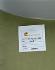 Green pillow with a label from Champo CarPets on a plain background