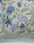 Decorative pillow with floral embroidery on a textured surface