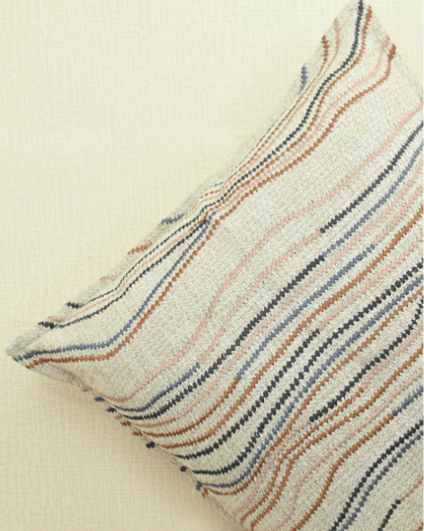 Ivory cushion cover with embroidered flowy lines in warm tones, perfect accent for home décor.