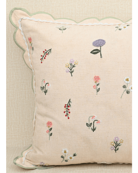 Tea Rose pink cushion with floral motifs in lavender and peach, featuring scalloped edges for a touch of elegance.