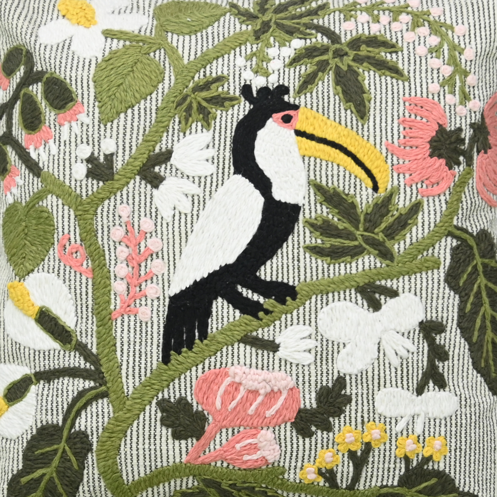 Embroidered toucan on a branch with flowers and leaves