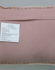 Pink pillow with a label on a gray background