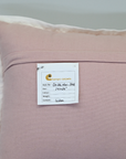Pink pillow with a label on a gray background