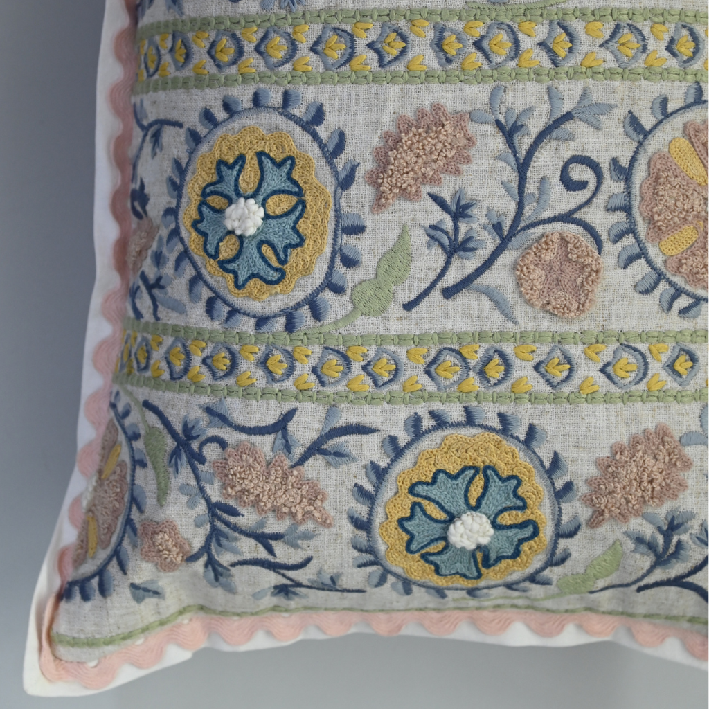 Decorative pillow with intricate floral and geometric patterns on a plain background