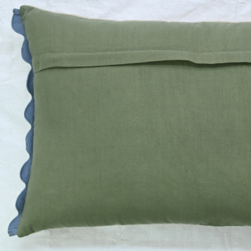 Green pillow with blue trim on a white background